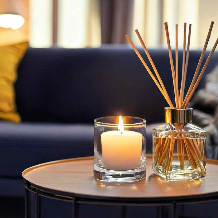 cosy living room with a candle and a glass reed diffuser on a coffee table